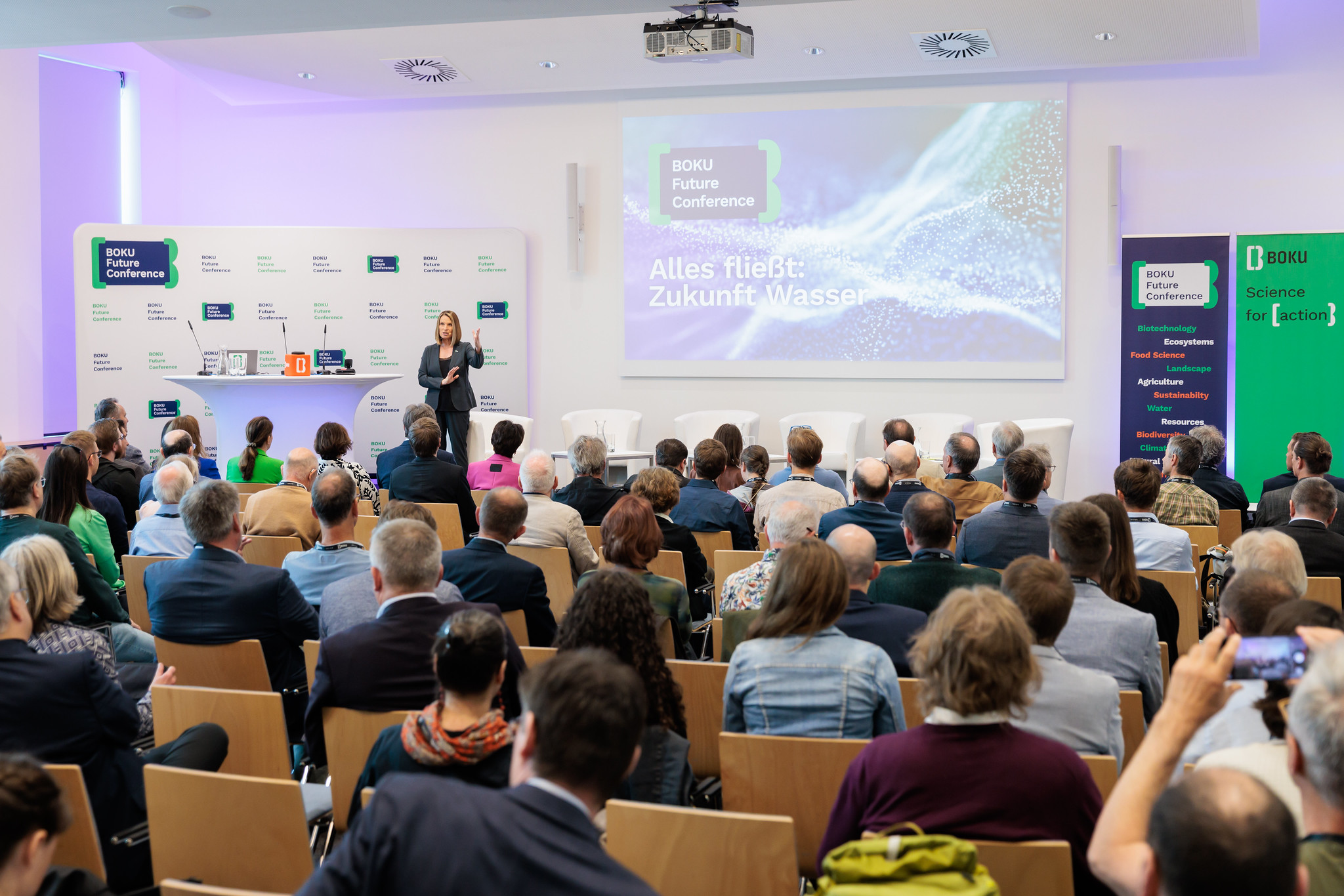 Voll besetzter Hörsaal, Moderatorin Barbara Stöckl eröffnet die BOKU Future Conference 2025 mit dem Thema Alles fließt: Zukunft Wasser