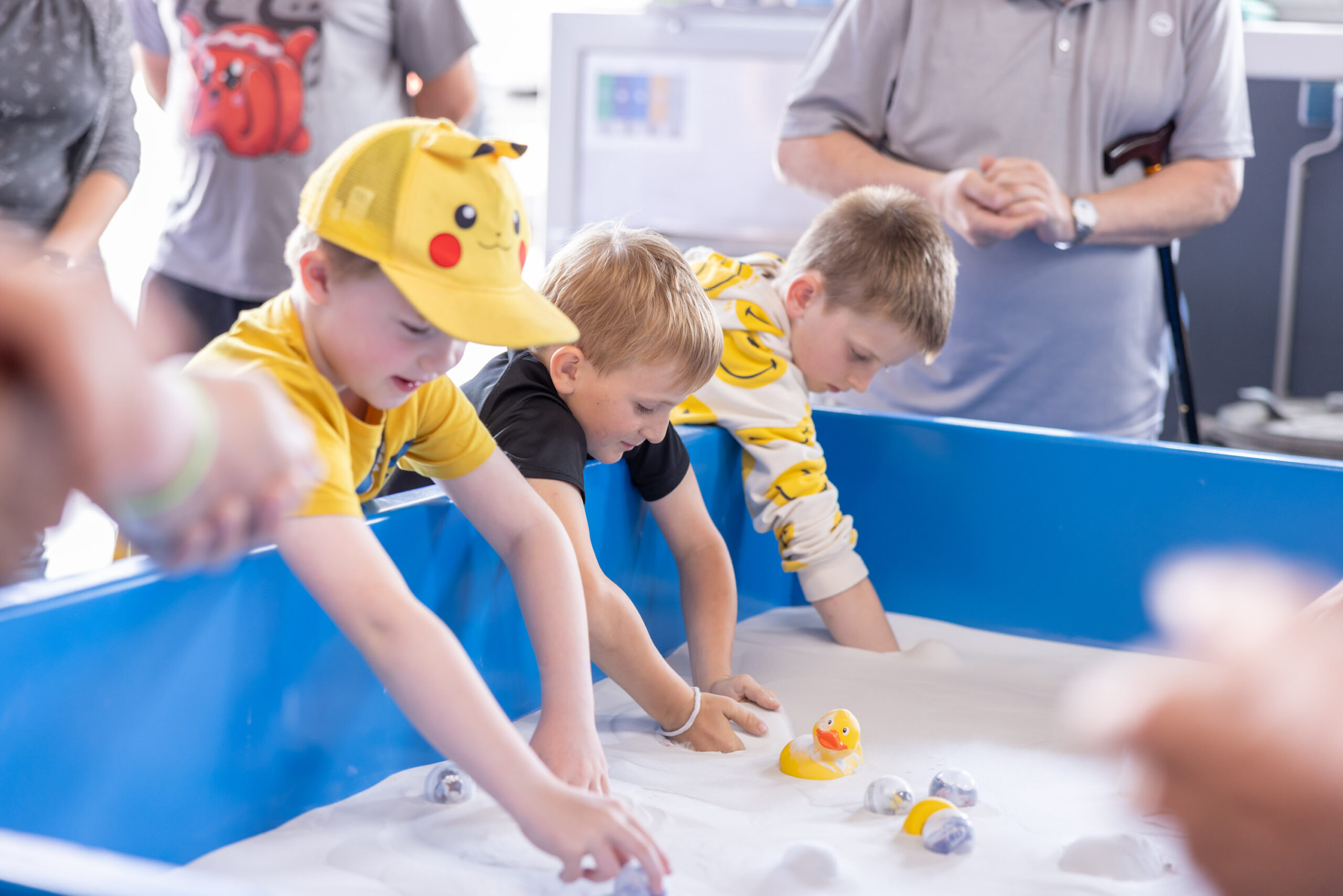 Kinder fischen nach Spielzeug-Enten in einem Plantschbecken