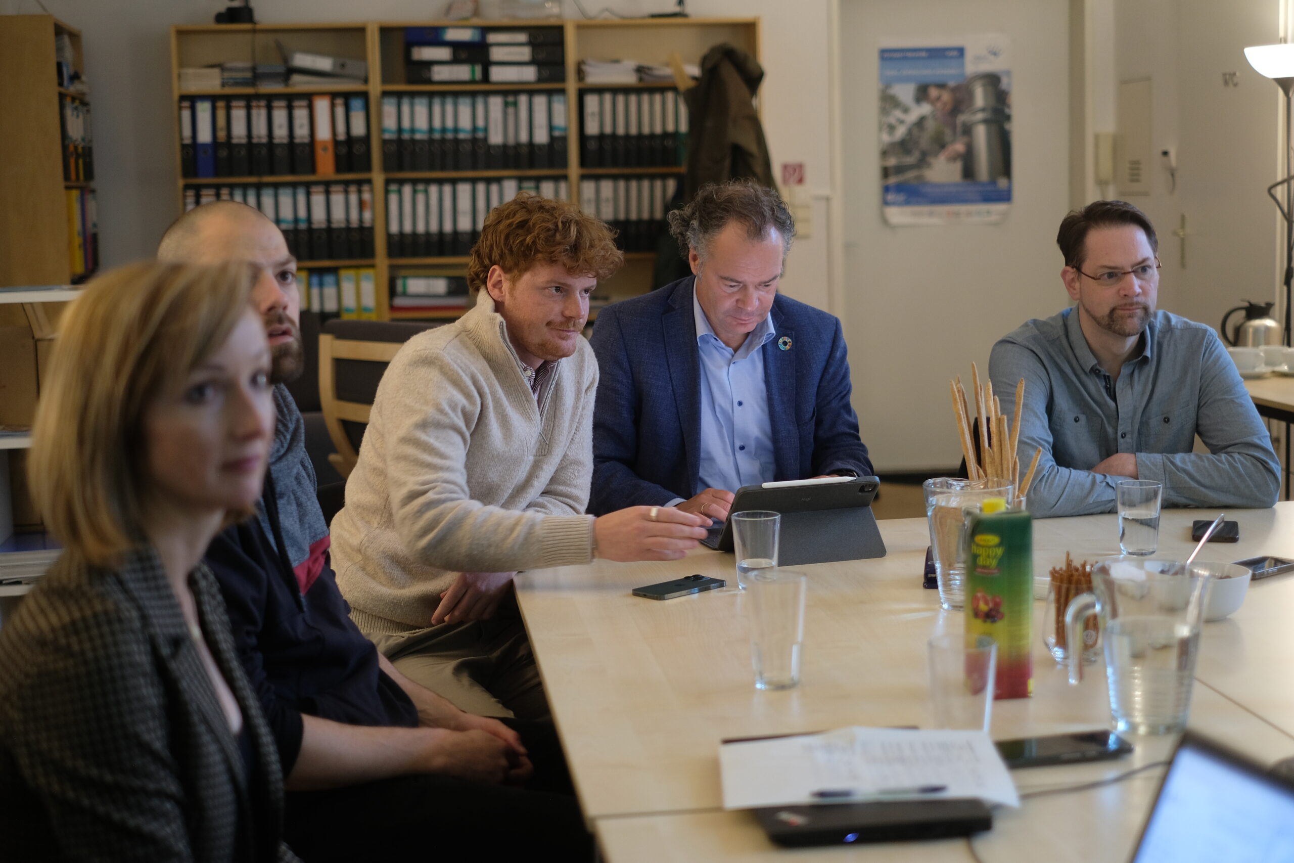 Fünf Eigentümer sitzen an Tisch und erarbeiten Lösungen für ihre Liegenschaften