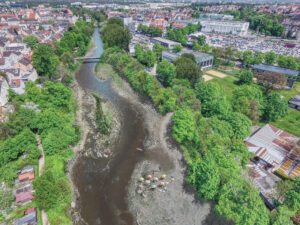 Visualisierung des Flusses Wertach im natürlichen Flusslauf mit Bäumen und Liegewiese